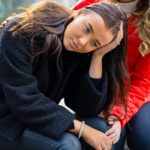 Friend Consoling Unhappy Young Woman In City