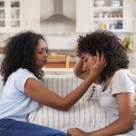 Mother Talking With Unhappy Teenage Daughter On Sofa